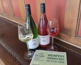 Weinpreis 2026: die Siegerweine 2 Weinflaschen, 2 Weingläser mit Terminhinweis Weinfest